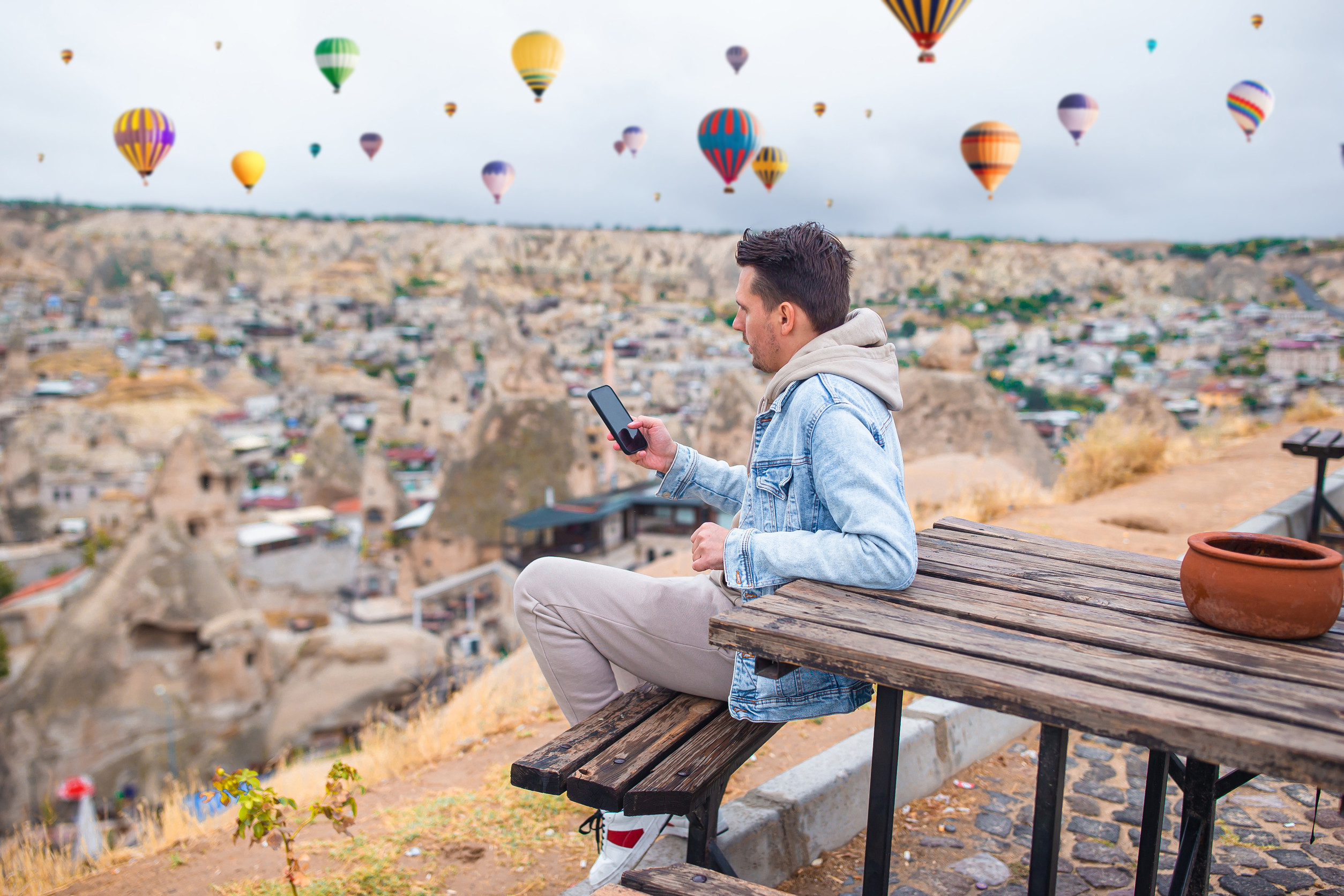 happy young- man watching hot air balloons in cappadocia turkey